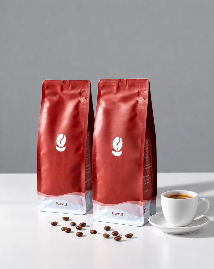 Daily Essentials: two 300g Bean Shipper bags and an espresso cup on a white table against a grey wall
