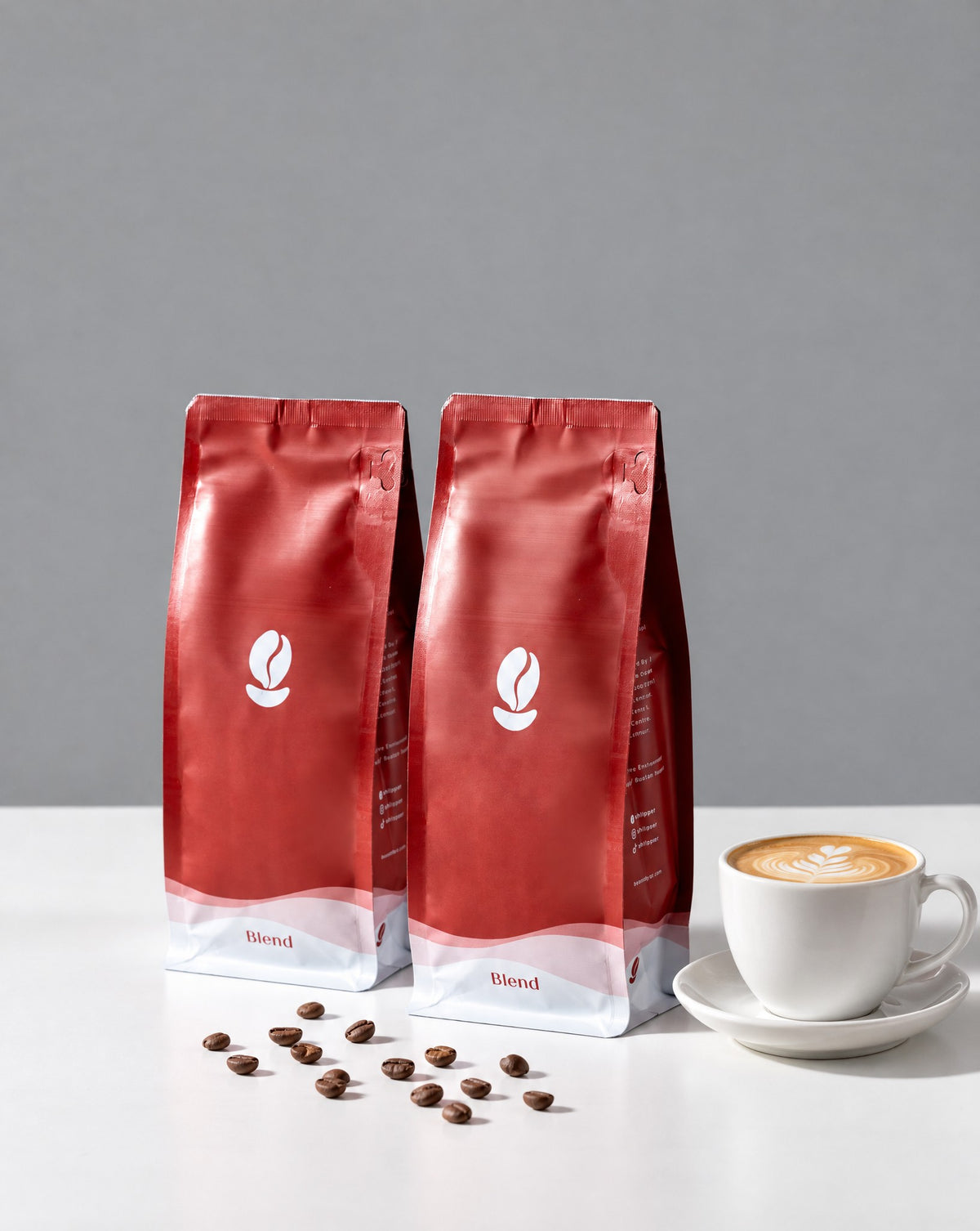 Dark Roast Bundle: two 300g Bean Shipper bags and a flat white on a white table against a grey wall