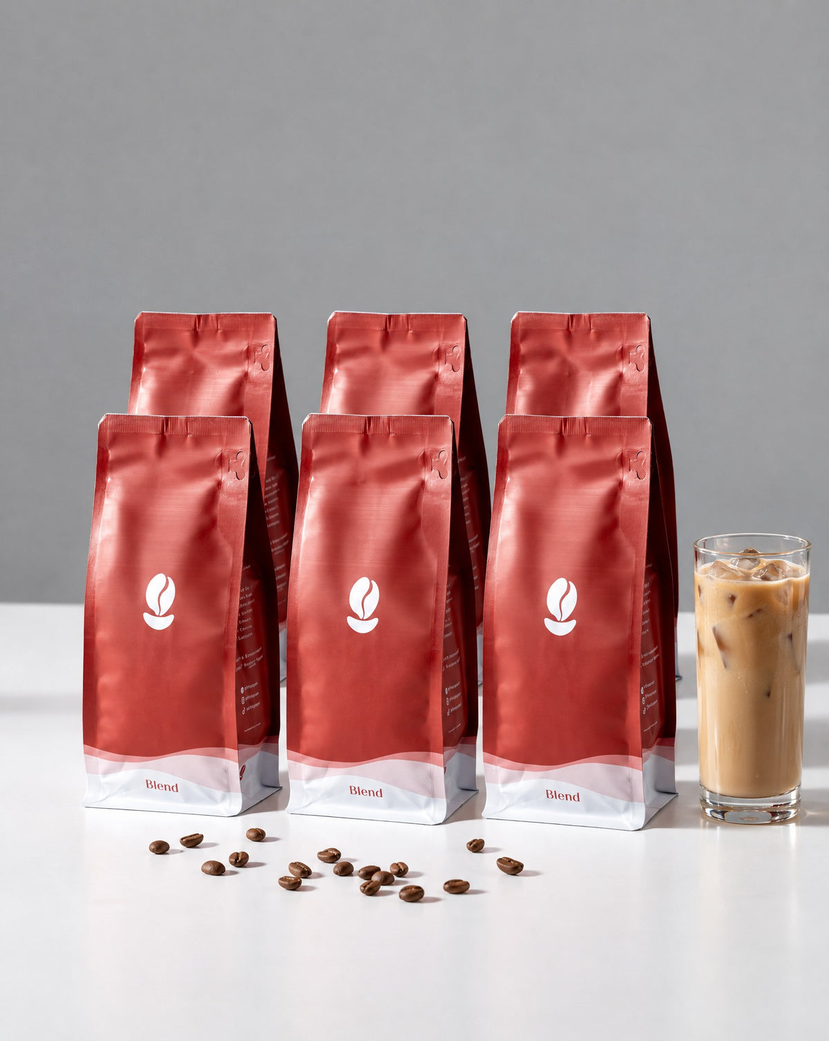 The Dessert Table: six 300g Bean Shipper bags and an iced latte on a white table against a grey wall