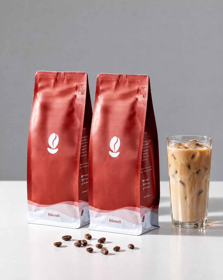Liberica Duo, Blend: two 300g Bean Shipper bags and an iced latte on a white table against a grey wall