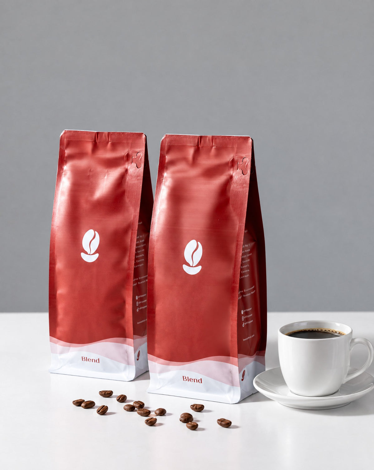 Liberica Duo, Single Origin: two 300g Bean Shipper bags and a cup of black coffee on a white table against a grey wall